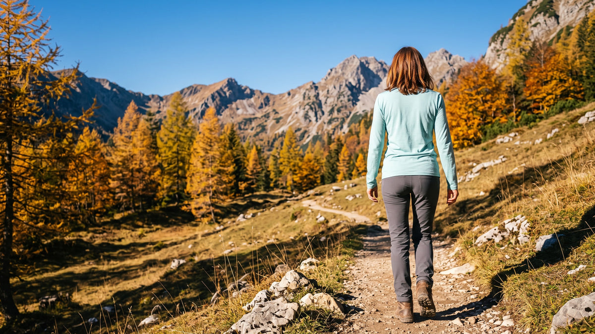 Wanderin im türkisen Merino Langarmshirt auf einem Wanderweg im Allgäu im Herbst