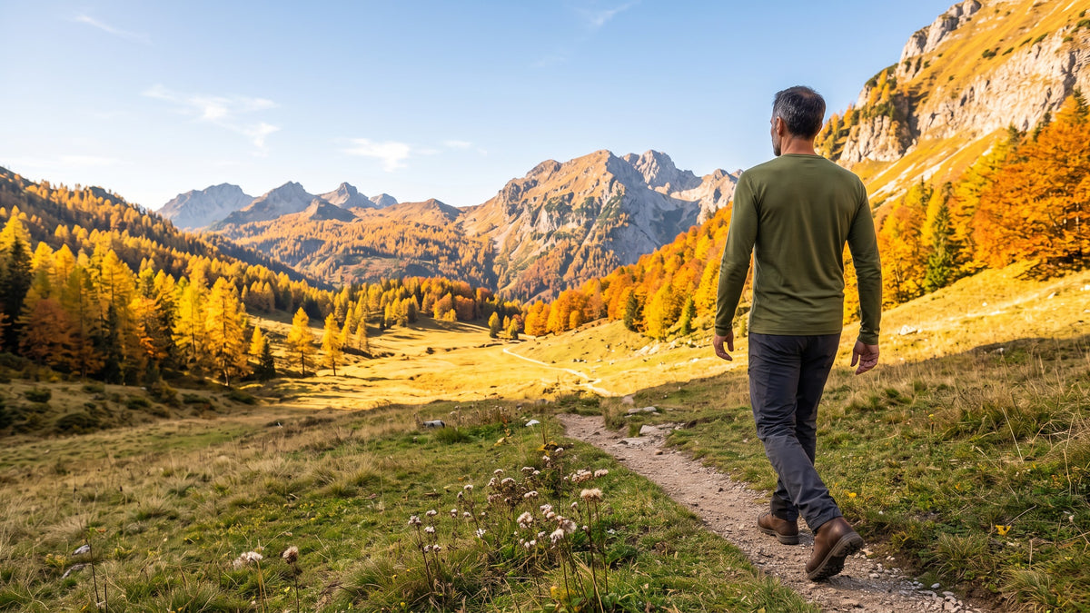 Wanderer im Merino Langarmshirt zwischen goldenen Lärchen in den Berchtesgadener Alpen